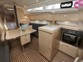 A beautifully designed boat interior featuring a cozy dining area and modern kitchen amenities, perfect for comfortable cruising and entertaining.