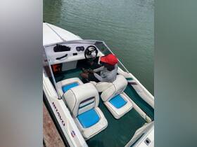 A view of the interior of a Bravo boat, showcasing the helm and seating area, with a person seated at the controls, ready for an adventure on the water.