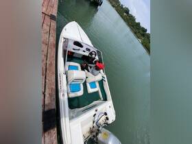 A person relaxes in the helm area of a Bravo boat, showcasing the comfortable seating and interior layout, perfect for a day on the water.