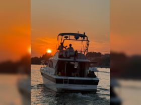A couple enjoys a romantic moment on a boat at sunset, creating a picturesque backdrop for memorable cruises.