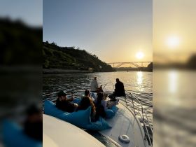 A group of friends enjoys a relaxing evening on a boat at sunset, surrounded by scenic views — perfect for memorable gatherings and celebrations on the water.