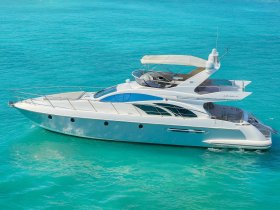 A stunning aerial view of a luxurious yacht cruising through crystal-clear turquoise waters, perfect for upscale charters and island adventures.