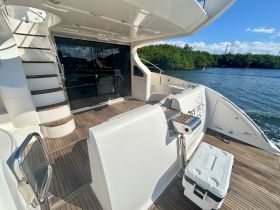 A spacious interior view of a yacht featuring elegant seating and a stylish staircase, perfect for relaxing on the water.
