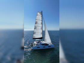 A stunning aerial view of a sleek catamaran sailing gracefully on clear blue waters, perfect for exploring coastal destinations.