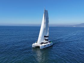 A stunning aerial view of a sleek catamaran sailing smoothly across the deep blue ocean, showcasing the beauty of maritime adventures.