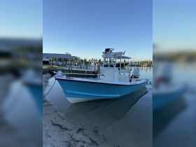 A vibrant blue speedboat docked at the marina, showcasing its sleek design against a clear sky — perfect for fishing or leisure outings.