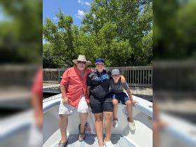 A family enjoys a sunny day on a boat, capturing a moment of togetherness and fun on the water.
