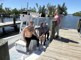 A cheerful group of friends poses on their boat at the dock, ready for a day of adventure on the water.