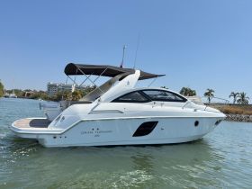 A sleek Gran Turismo 35 yacht docked in calm waters, showcasing its elegant design against a clear blue sky.