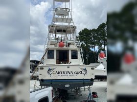 The 'Carolina Girl' boat is docked and undergoing maintenance, showcasing its rear view and distinctive name — a perfect vessel for fishing adventures in Murrells Inlet, SC.