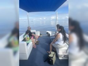 A family enjoys a relaxing moment aboard a boat, surrounded by calm waters and clear skies — perfect for creating lasting memories on the water.