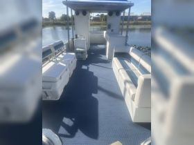Interior view of a spacious boat cabin featuring comfortable seating and a helm, ideal for relaxing while enjoying scenic waterways.