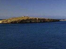 A stunning view of a secluded island with a lighthouse, surrounded by tranquil blue waters — perfect for exploring coastal destinations.