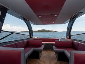 Interior view of a stylish lounge area on a boat, featuring comfortable seating and panoramic views of the surrounding waters — perfect for relaxing while cruising.