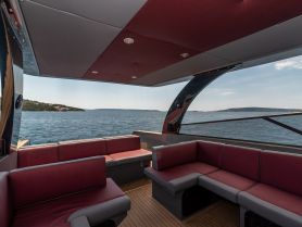 A spacious and stylish lounge area inside a boat, featuring comfortable seating and panoramic views of the water, perfect for relaxing during a day on the water.