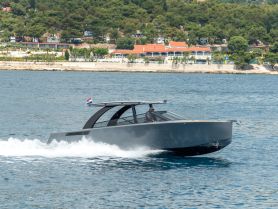 A sleek speedboat cruising through clear waters, showcasing its modern design and performance on the open sea.