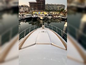 A stunning view from the front of a yacht docked in a marina, showcasing the sleek design and surrounding boats, perfect for luxury cruising.