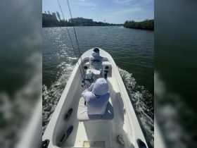 Two anglers enjoy a day of fishing on a boat, navigating through calm waters — a perfect setting for fishing enthusiasts.