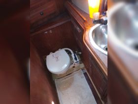 Interior view of a boat's bathroom featuring a toilet and sink, showcasing the essential amenities for comfort on board.