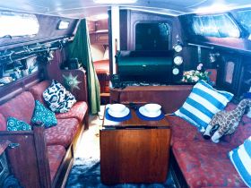 Cozy interior of a sailboat featuring comfortable seating and a well-equipped cabin, perfect for relaxing during your nautical adventures.