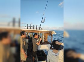A group of friends enjoys a fishing trip on a boat, showcasing the excitement of ocean fishing and camaraderie on the water.