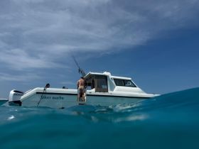 A group of people enjoys a day on the water aboard the Silver Marlin, showcasing the excitement of on-water activities under a clear blue sky.