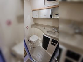 Interior view of a boat bathroom featuring a toilet and sink, showcasing the compact design typical of marine vessels.