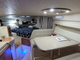 Interior view of a cozy boat cabin featuring a comfortable sleeping area and a dining table, perfect for relaxation and meals on the water.