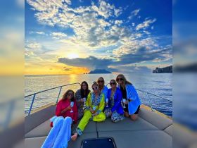 A group of friends celebrates with cocktails on a yacht at sunset, creating a perfect backdrop for memorable moments on the water.