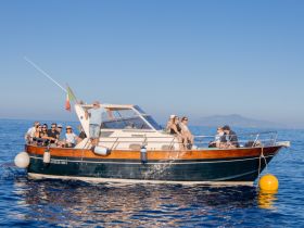 A lively group of friends enjoys a day on the water aboard a charming boat, perfect for celebrations and memorable outings in the ocean.