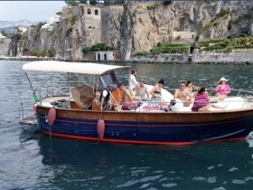 A lively group enjoys a day on the water aboard a charming boat, perfect for summer gatherings and fun on the Amalfi Coast.