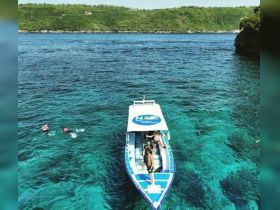 A vibrant scene of a group enjoying snorkeling in crystal-clear turquoise waters, with a boat nearby, perfect for adventurous outings and aquatic exploration.