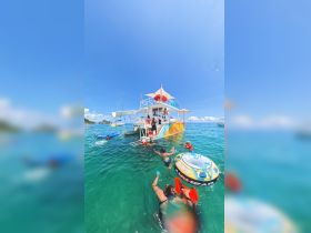 A lively group enjoys a fun day of swimming and snorkeling around a colorful boat, perfect for family adventures and water activities.
