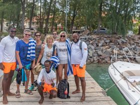 A cheerful group of friends poses together at the dock, ready for a fun day on the water. Their vibrant attire and smiles capture the excitement of a memorable boating adventure.
