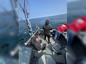 A group of friends enjoys a fishing trip on a boat, showcasing the excitement of angling in open waters.