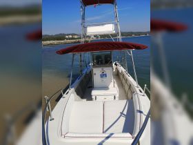 Interior view of a well-equipped boat featuring comfortable seating and a console, perfect for a day on the water.