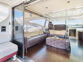 A stylish interior view of a boat's lounge area featuring comfortable seating and elegant decor, perfect for relaxing while on the water.