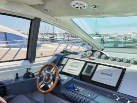 The interior view of a boat's helm showcases modern navigation equipment and a sleek design, perfect for steering adventures on the water.