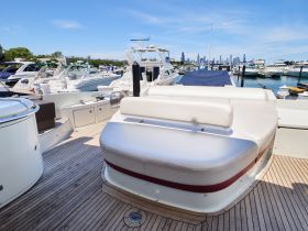 A spacious seating area inside a boat, showcasing the comfortable lounge setup perfect for relaxing while enjoying views of the marina.