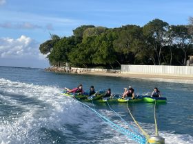 A group of friends enjoys an exhilarating tubing experience on the water, showcasing the thrill of water activities and summer fun.