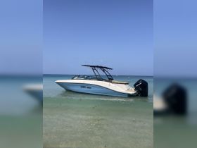 A sleek speedboat rests in shallow waters, showcasing its elegant design against a clear blue sky — perfect for summer adventures on the water.