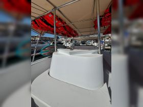 Interior view of a boat showcasing comfortable seating and safety equipment, ideal for a relaxing day on the water.