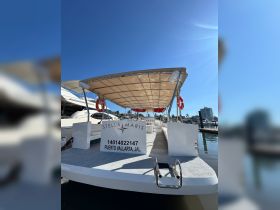 The Stella Maris boat is docked in Puerto Vallarta, showcasing its spacious deck and inviting design, perfect for group outings on the water.
