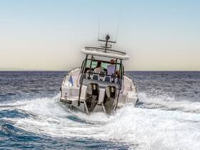 A sleek speedboat navigates through the waves, showcasing its powerful engines and modern design as it cruises across the open water.
