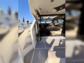 A spacious interior view of a luxury boat featuring a well-designed helm and comfortable seating area, perfect for relaxing during your nautical adventures.