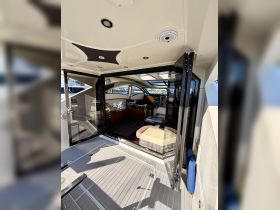 A spacious and modern interior view of a boat's cabin, showcasing comfortable seating and a well-equipped helm area, perfect for relaxing and navigating on the water.