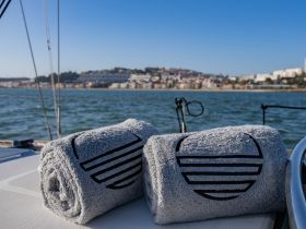 A pair of neatly rolled towels on the deck of a sailboat, perfect for enjoying a day on the water with comfort and style.