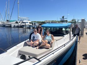 A group of friends enjoys a sunny day on a boat at the marina, capturing the essence of fun and relaxation on the water.