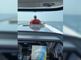 A person navigates a boat while enjoying a scenic view of the open water, showcasing the thrill of boating adventures.