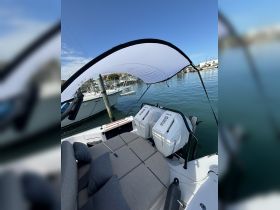 A cozy seating area inside a boat, featuring plush cushions and a view of the engines, perfect for relaxing while enjoying a day on the water.